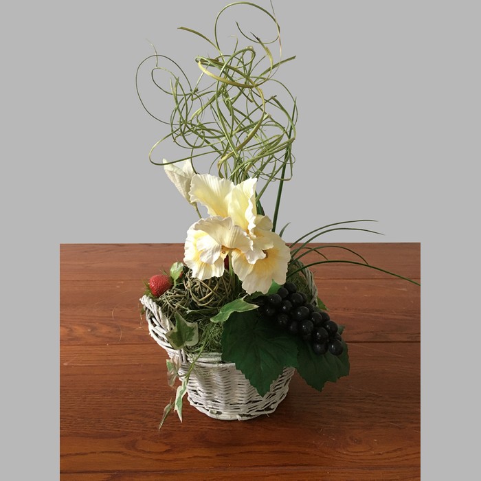 Flower arrangement with iris and grapes in basket